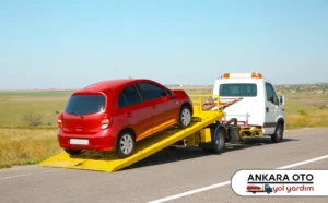 Kırmızı otomobilin çekici platformunda taşınması